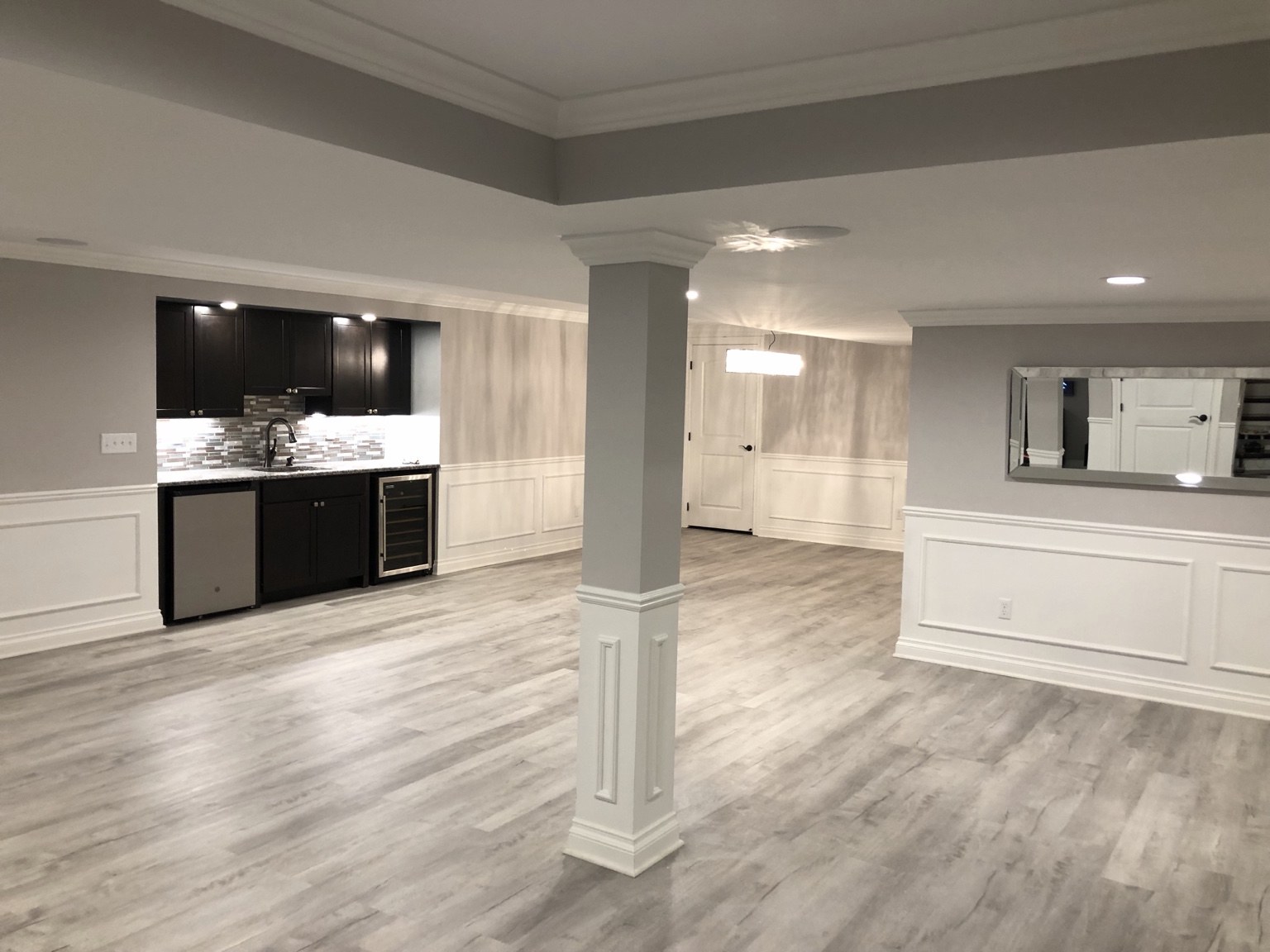 Finished basement with wet bar and detailed column trim
