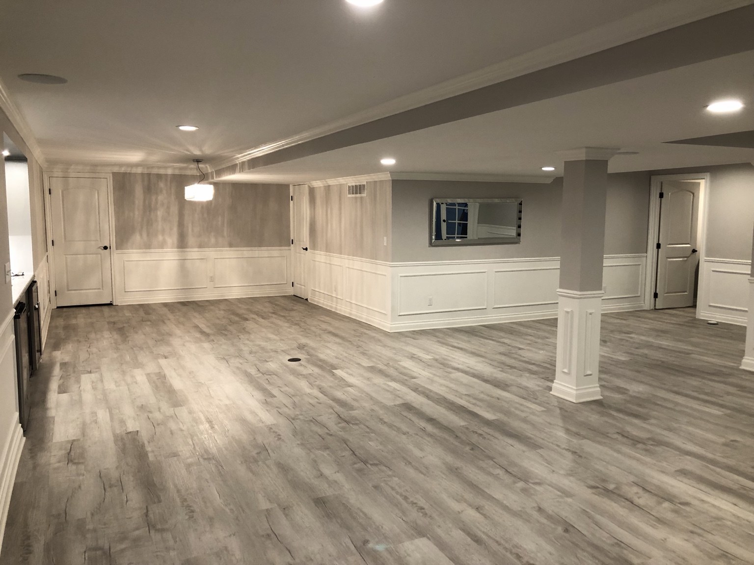 Open finished basement with recessed lighting and wall paneling