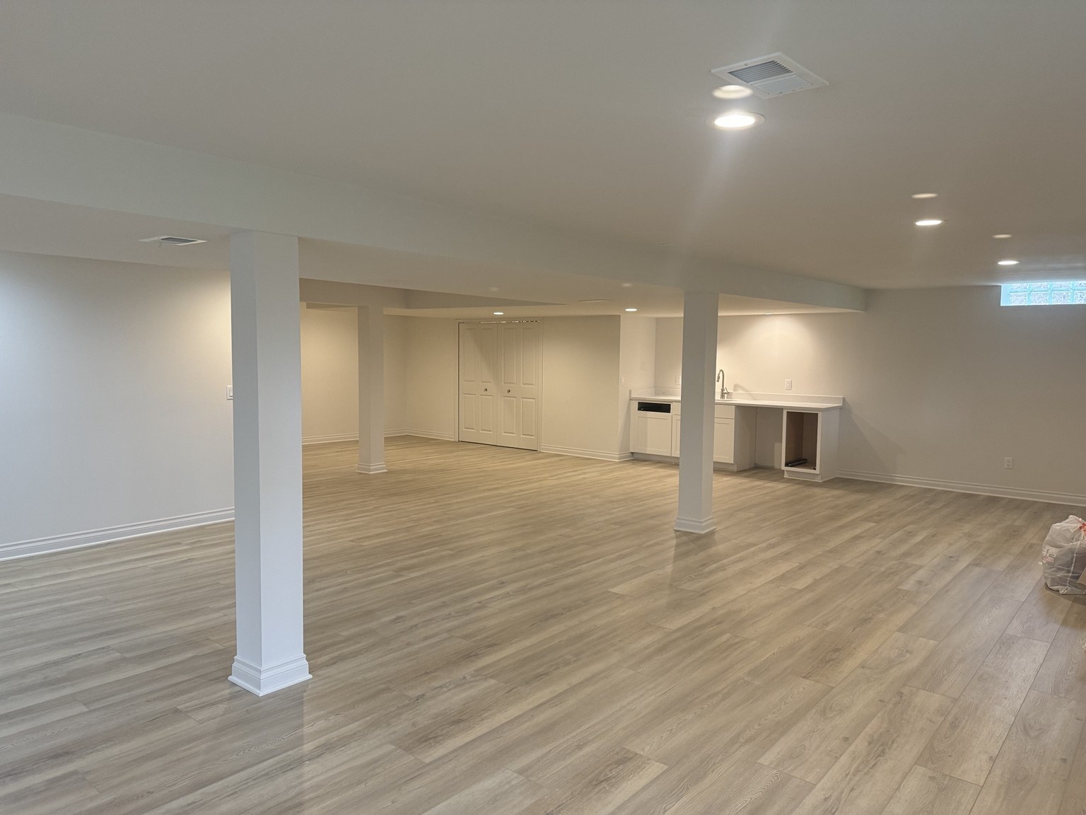 Spacious finished basement with recessed lighting and wet bar