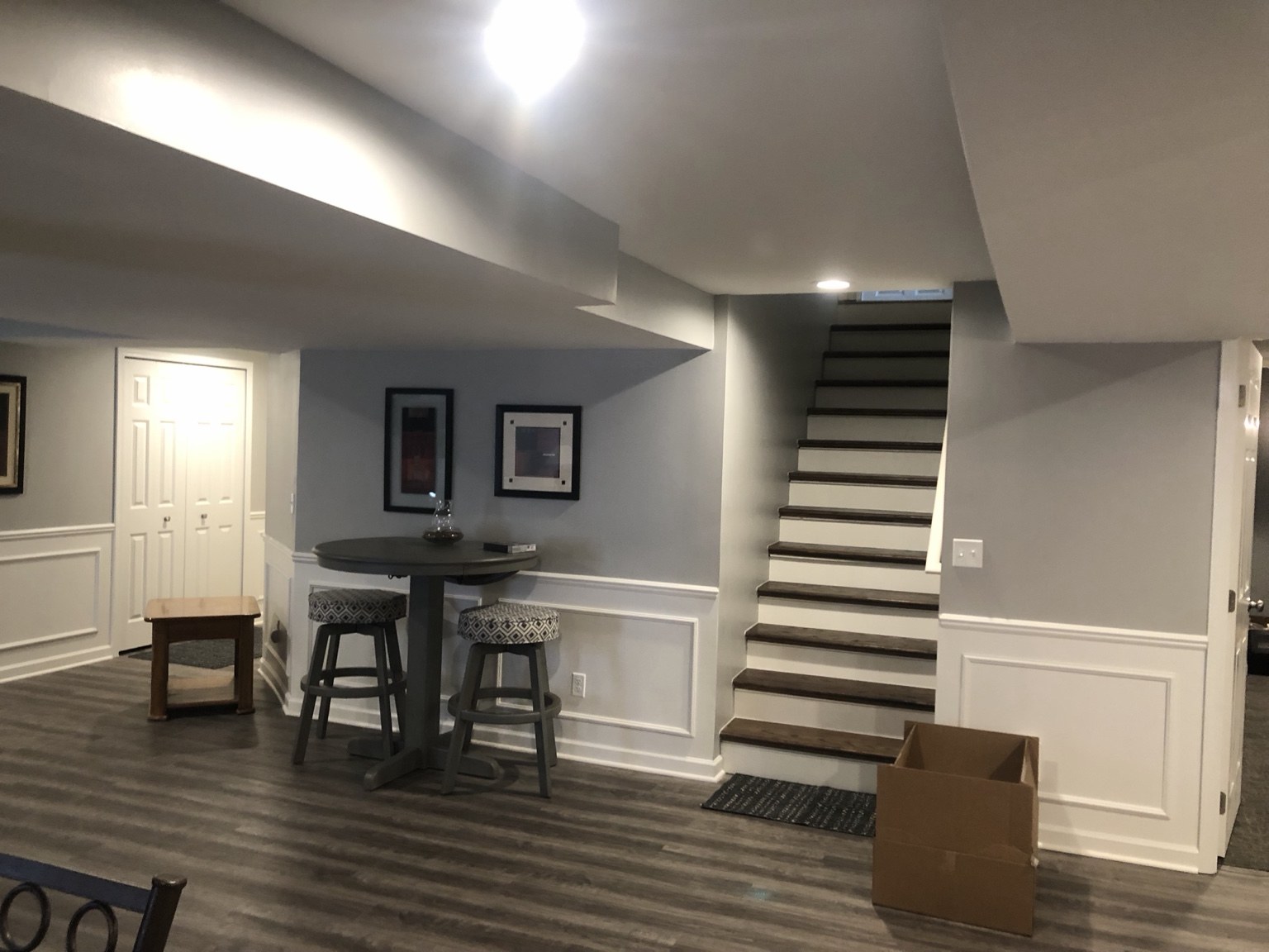 Finished basement staircase with white trim and dark flooring