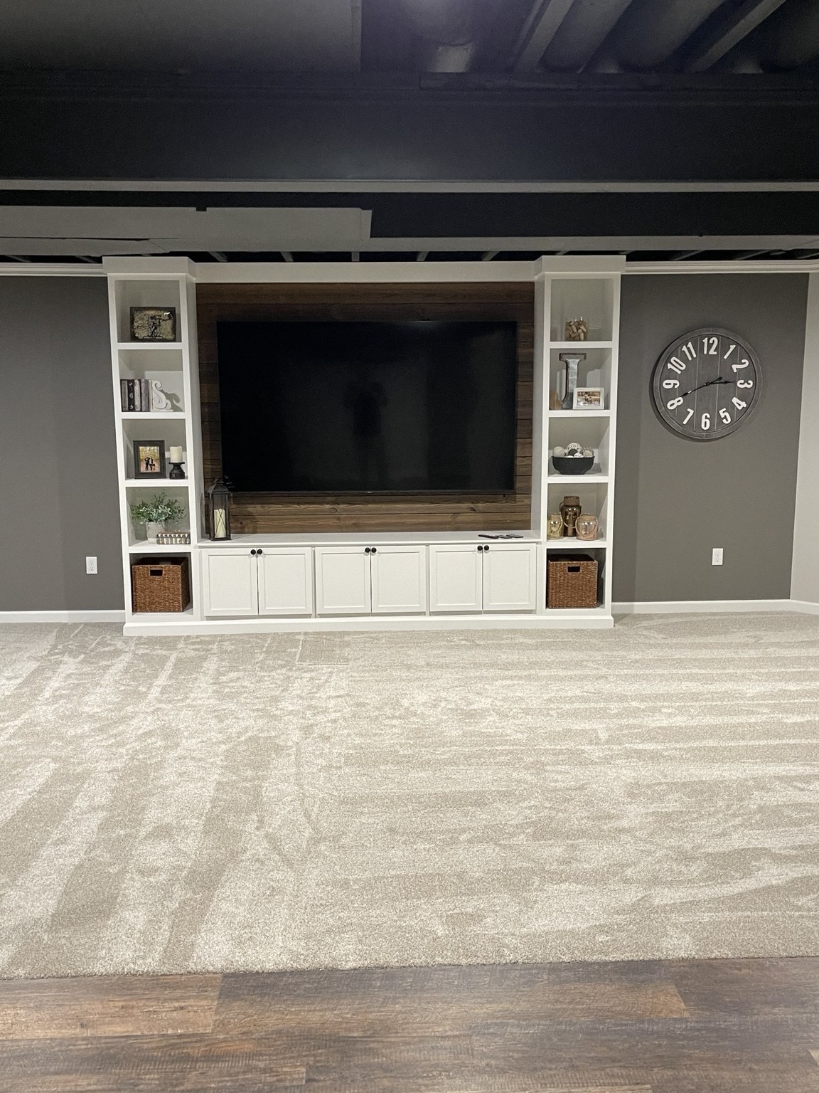 Basement entertainment wall with television and built-in shelving