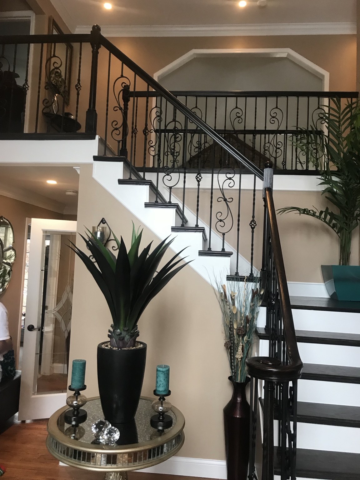 Custom staircase with dark handrails and decorative iron spindles
