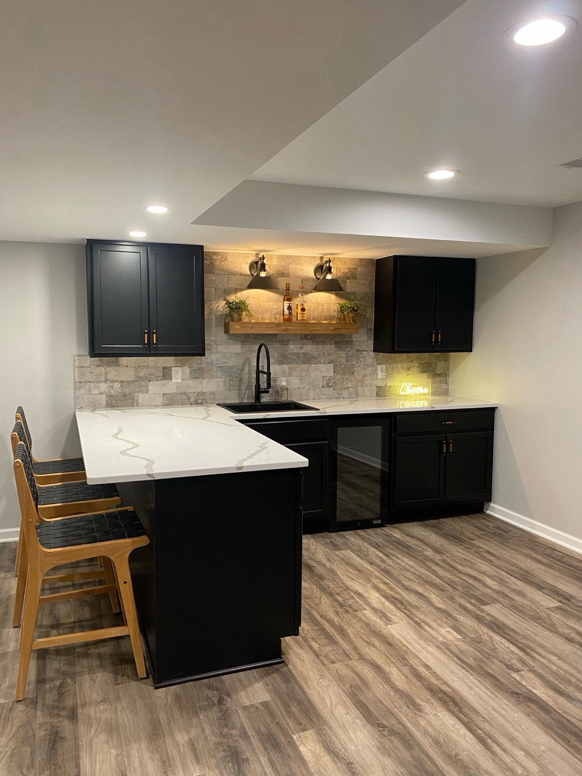 Basement bar with dark cabinets and peninsula countertop