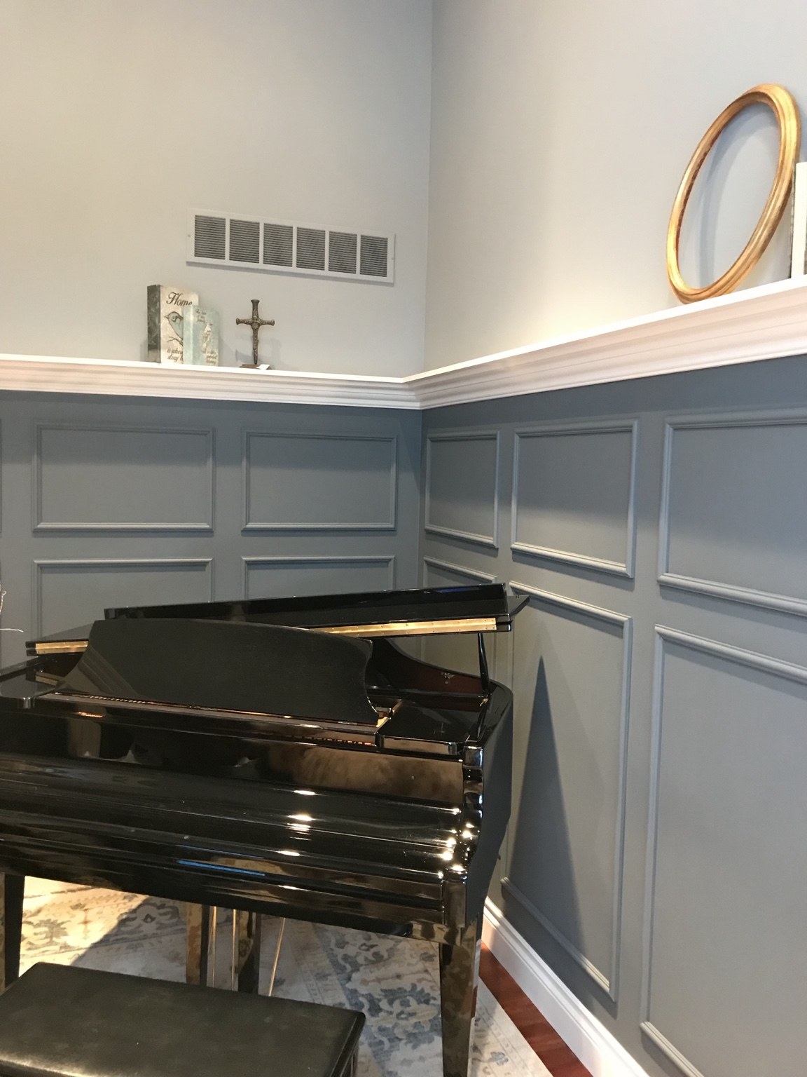 Decorative wall panel molding beside a grand piano