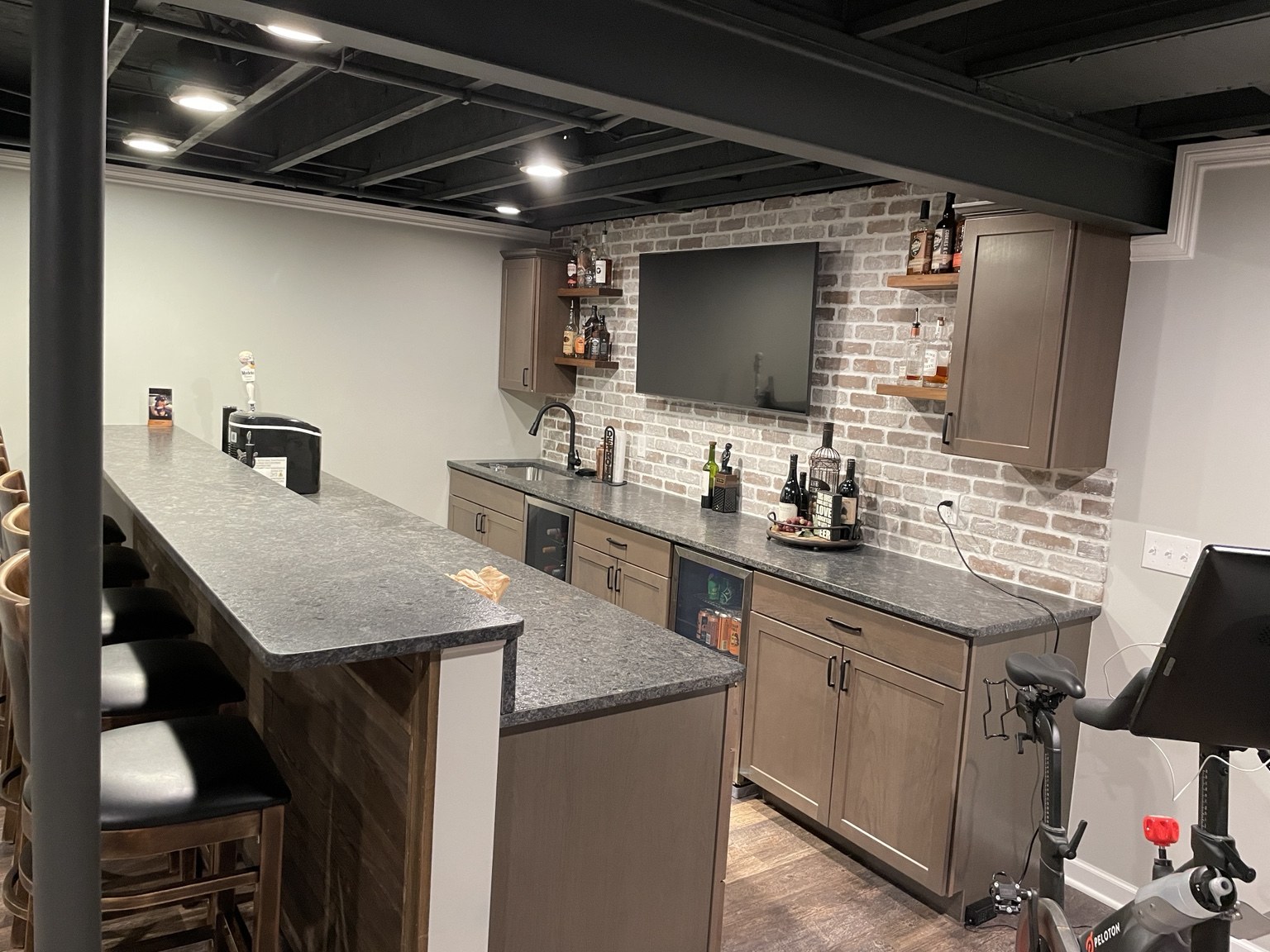 Basement wet bar with brick backsplash and seating